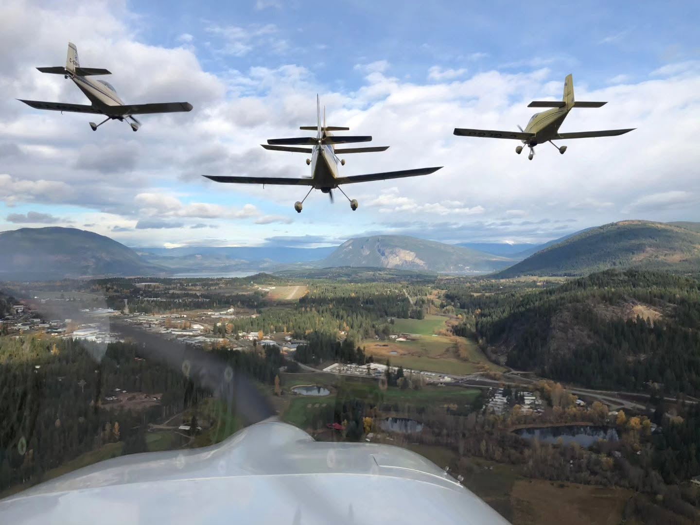 Three club aircraft flying in formation over Salmon Arm and the Shuswap valley