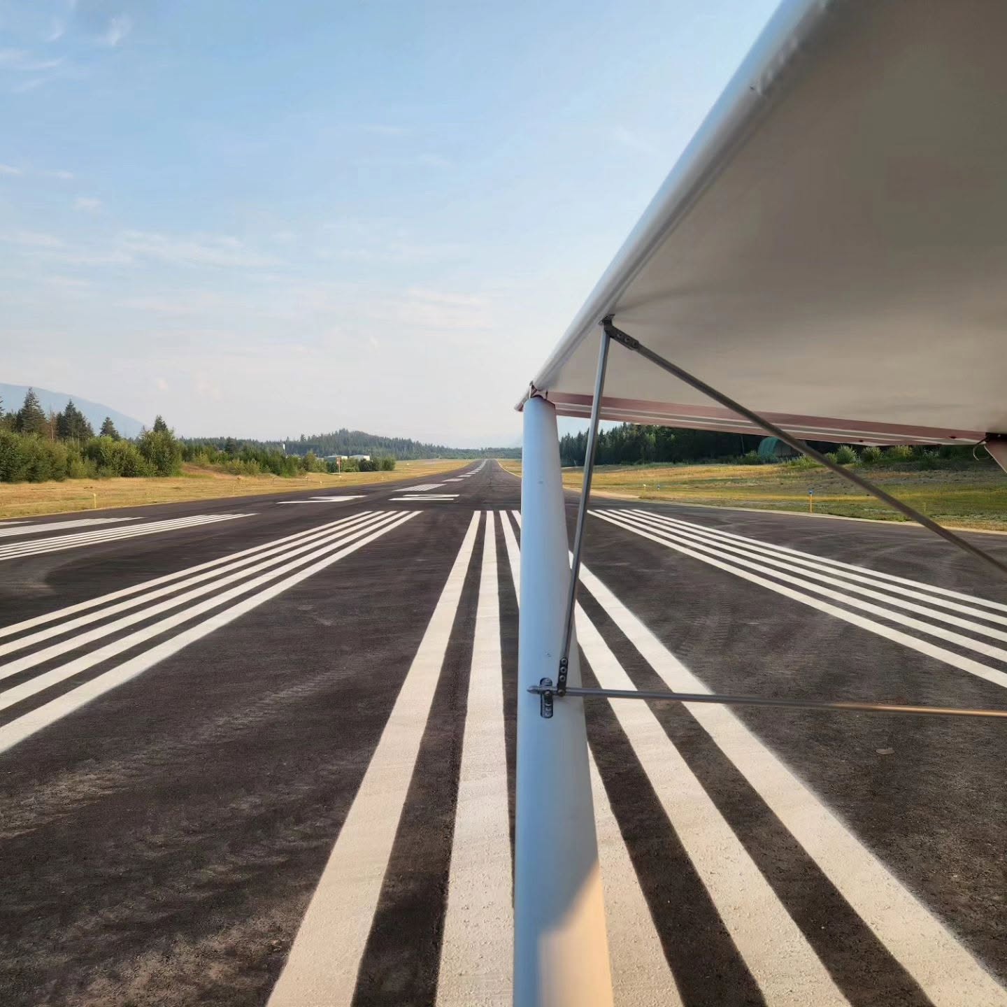Looking down the runway at the Salmon Arm airport from beneath a high-wing aircraft